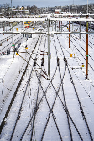 Urban winter landscape with a view of a multiline railway line with a moving electric train on a clear frosty day.の写真素材