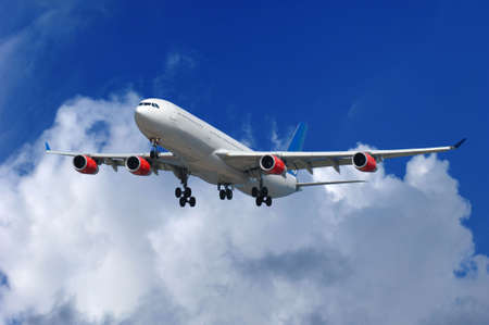 Big airliner on blue and cloudy sky.