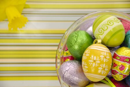 Easster eggs and yellow flower on a striped background.
