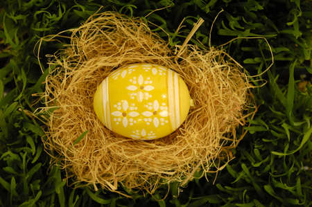 Easter egg in nest on green grass.