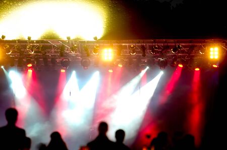 Crowd of people in front of spotlights at a concert.