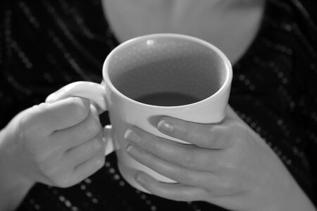 Hands holding coffee in the morning, black and white monochromeの写真素材