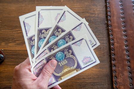 Hand Holding Uzbekistani money, known as So'm.