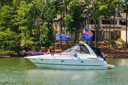 Mooresville, NC, USA - July 4, 2020: Luxury Boat flying Trump 2020 flags for President Donald Trump on Lake Norman near the Trump National Golf Club Charlotteのeditorial素材
