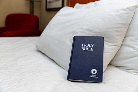 Hattiesburg, MS / USA - September 17, 2020: Blue Gideons Bible on bed in hotel roomのeditorial素材