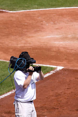 Television Cameraman video taping baseball game.