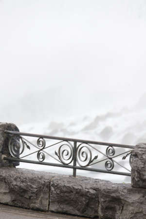 Stone and metal rail with a waterfall backgroundの写真素材