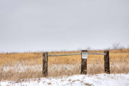 Wooden fence in field with posted no trespassing sign attachedの写真素材