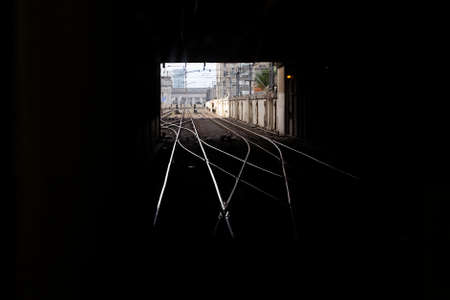 Train tracks leading out from a tunnel
