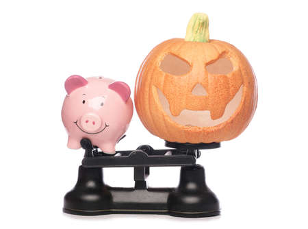Piggybank and pumpkin on scales studio cutoutの写真素材