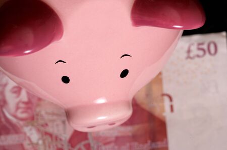Piggybank with fifty pound note on black backgroundの写真素材