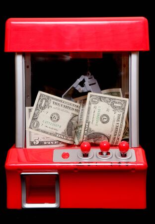 American money in a grabbing machine on black backgroundの写真素材
