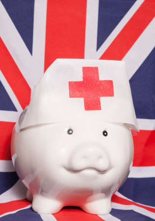 piggy bank wearing nurse hat on british flagの写真素材