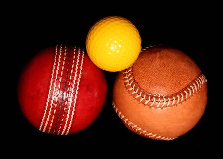 three different sport balls on black background