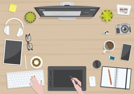 Wood textured table from top view with hands of woman drawing on digital graphic tablet with monitor, camera, tablet, headphones and gadgets, design for work from home conceptのイラスト素材