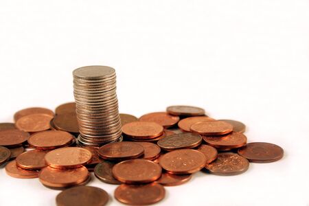 A single stack of coins rising above a bunch of pennies.