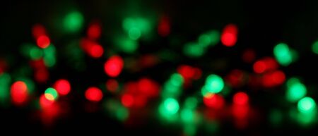Red and green Christmas lights, blurred to create a holiday background. の写真素材