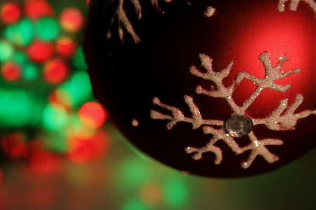 A closeup of the bauble with red and green christmas lights in the background.の写真素材