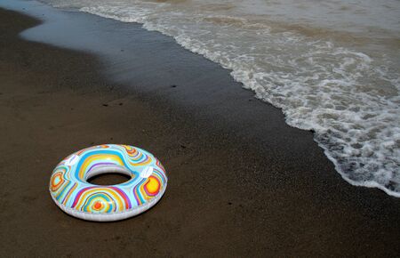 A float ring sitting on the beach as the tide comes in.の写真素材
