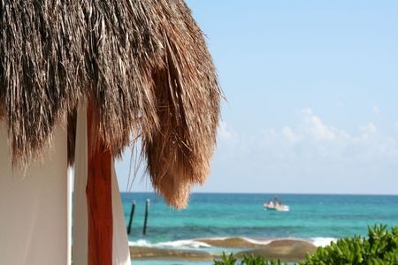A palm hut with the beautiful Carribean sea in the background.の写真素材