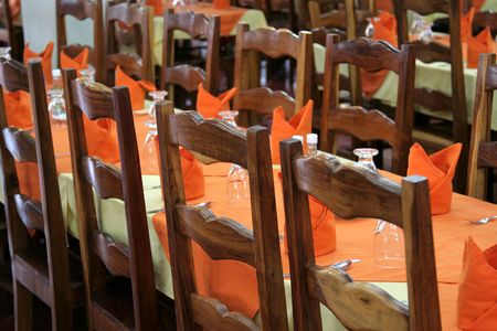 Dinner tables set with an orange decor.