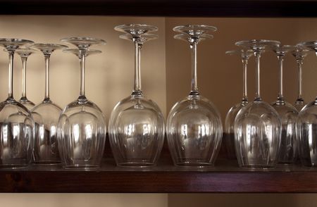 Lots of wine glasses sitting on a shelf.の写真素材