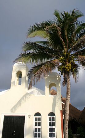 A tropical chapel with a palm tree beside it.の写真素材