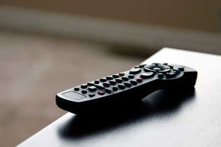 A remote control sitting on table in a living room.