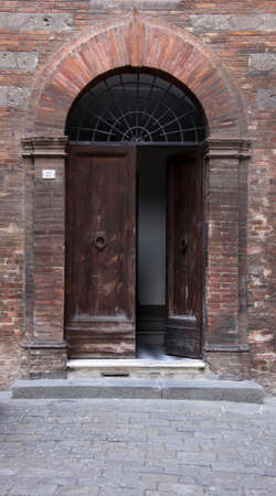 A medieval arched door in Siena, Italy.の写真素材