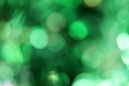 A green blurred background with dark and light patches.の写真素材