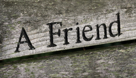 The words "A Friend" engraved on wood.の写真素材