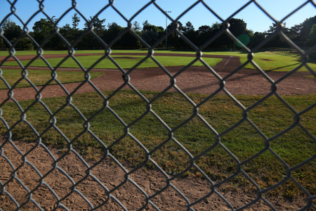 A baseball field shot through the fence in the early morning.の写真素材
