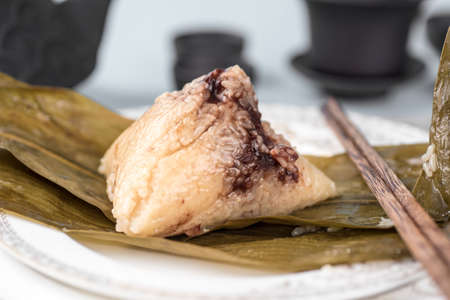 Chinese rice dumpling with bamboo leaves on plate