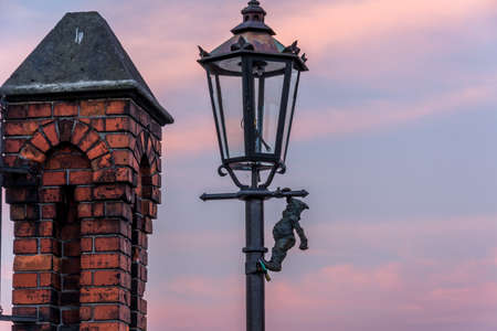 Dwarf on a lamp post on bridge in Wroclaw, Poland. Sunrise.の写真素材