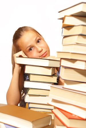 Preteen school girl with piles of books on white background                    の写真素材