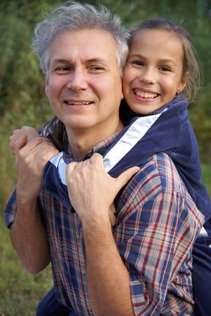 Cheerful father and daughter talking in parkの写真素材