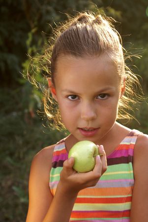 Preteen girl holding a fresh appleの写真素材