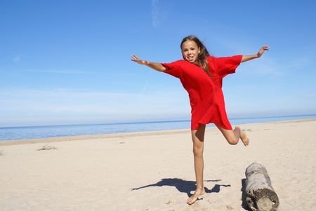 Cheerful preteen girl exercising on a beach                    の写真素材
