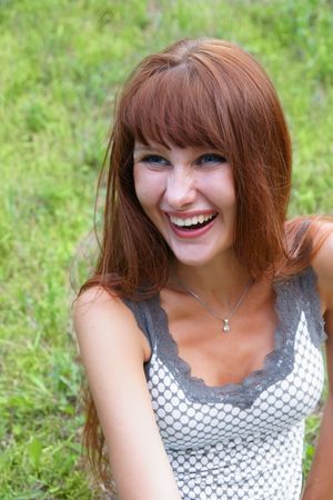 Happy young woman on grass backgroundの写真素材