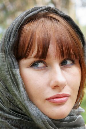 Beautiful red haired young woman in gray scarfの写真素材