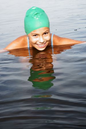 Cheerful preteen girl swimming in sea の写真素材