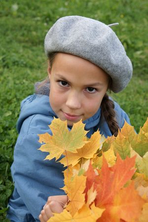 Preteen girl holding yellow leaves outdoorsの写真素材