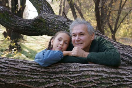 Happy father and daughter talking in autumn parkの写真素材