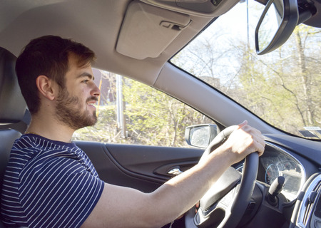 Handsome man hand on steering wheel driving car
