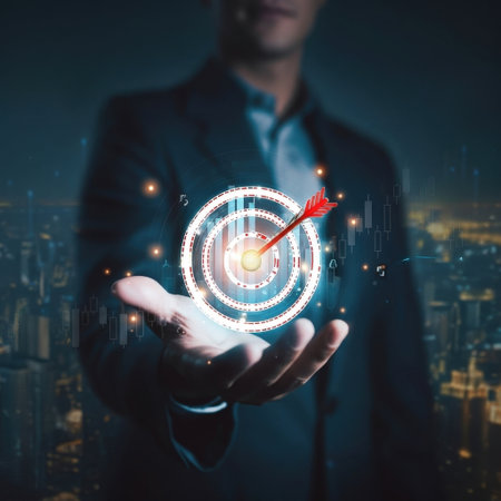 A businessman is holding a holographic target image in his hand, with an arrow pointing to the center. The image is set against a night cityscape background.の素材