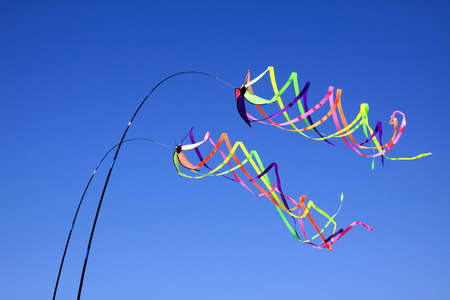 Two sets of coloured ribbons blowing in the windの写真素材