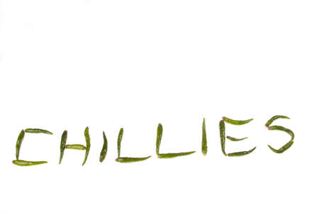 The word CHILLIES spelt out using fresh green chilli peppersの写真素材