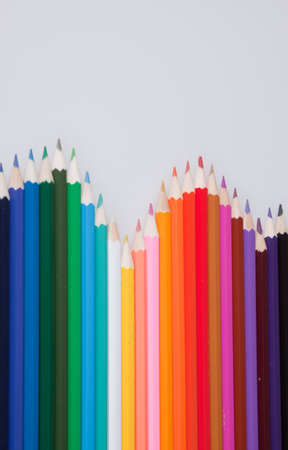 An assortment of coloured pencils isolated against a grey backgroundの写真素材