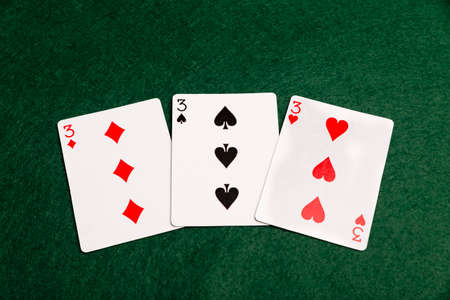 Three threes laid out on a green baize background.