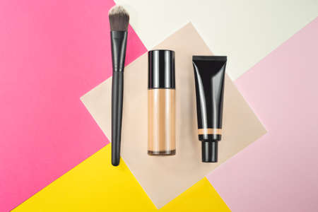 foundation bottles and make-up brush on a colored backgroundの写真素材